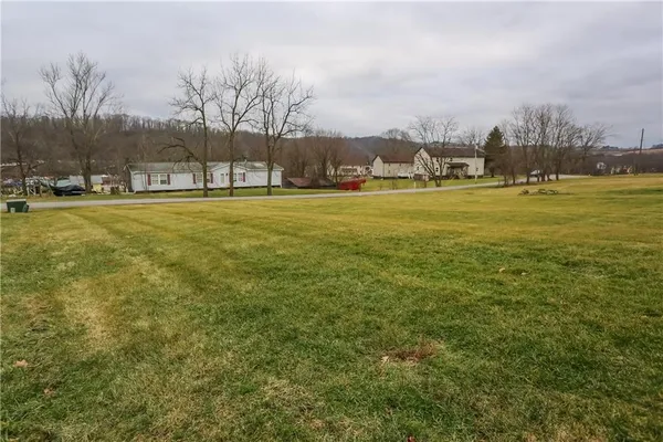 a view of yard with tree and wooden fence