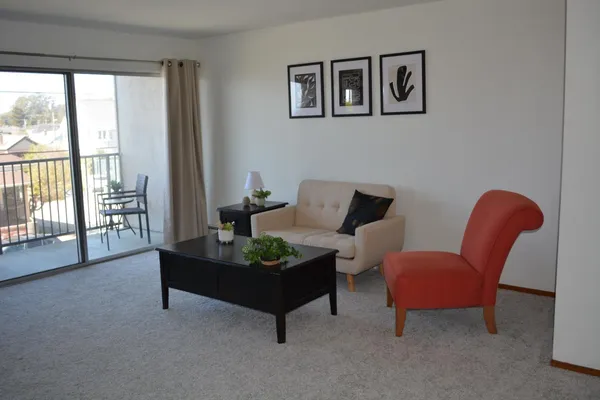a living room with furniture and a floor to ceiling window