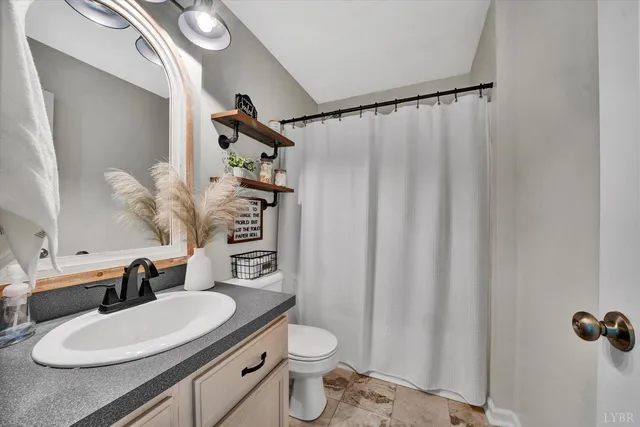 a bathroom with a sink a toilet and shower curtain