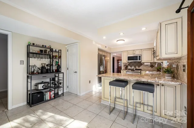 a kitchen with stainless steel appliances kitchen island granite countertop a stove and cabinets