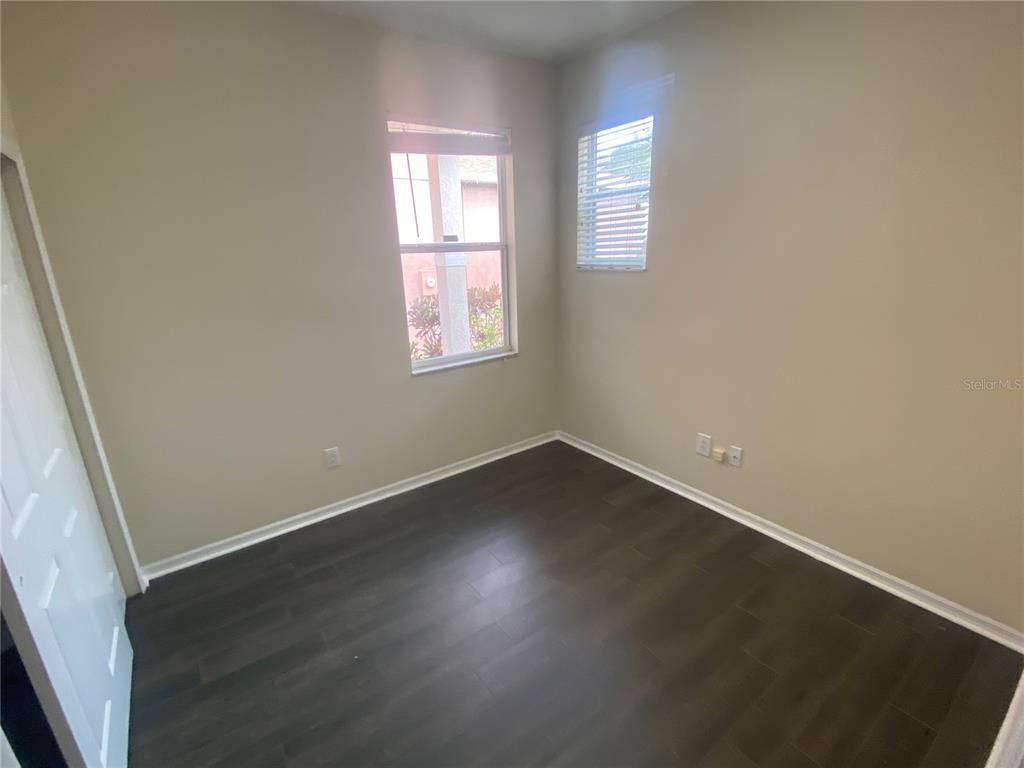 2409 Spring Hollow Loop Wesley Chapel, FL 33544 - Photo 16 of 47 an empty room with wooden floor and windows