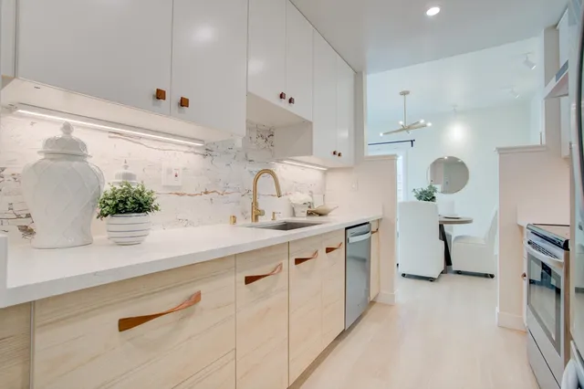 a kitchen with kitchen island white cabinets and white appliances