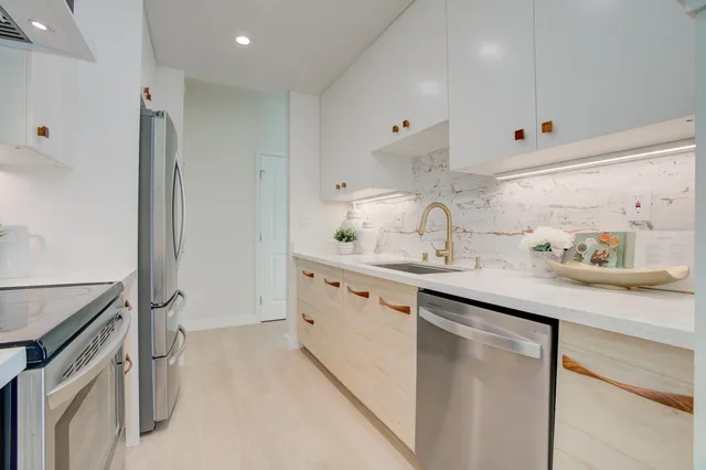 a kitchen with stainless steel appliances a sink stove and cabinets
