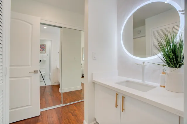 a bathroom with a sink a glass door shower and a mirror
