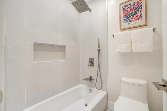 a white bath tub sitting next to a white toilet