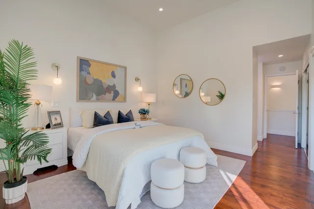 a spacious bedroom with a bed and a potted plant