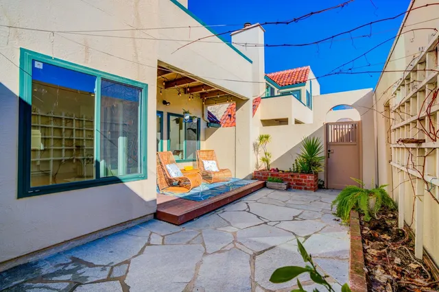 a backyard of a house with barbeque oven table and chairs