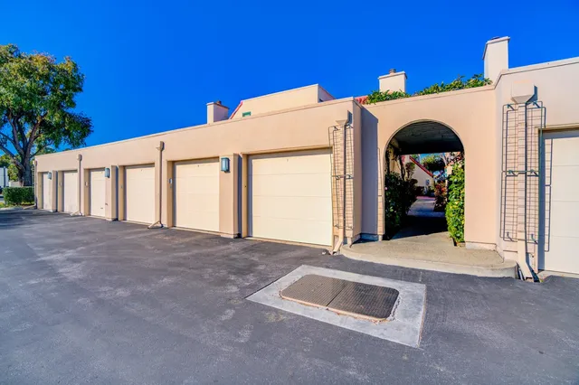 a view of a white house with a big yard and large tree
