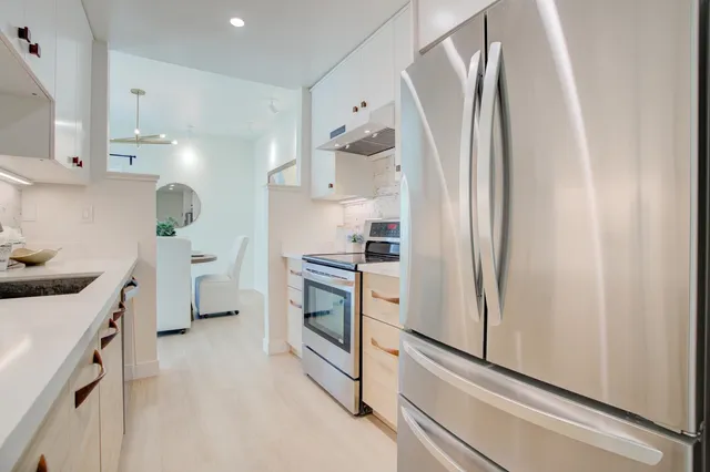 a kitchen with stainless steel appliances a refrigerator and a stove top oven