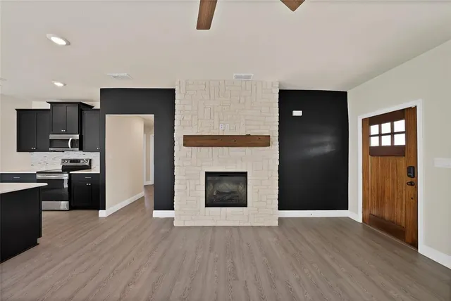 a kitchen with granite countertop a refrigerator and a stove top oven