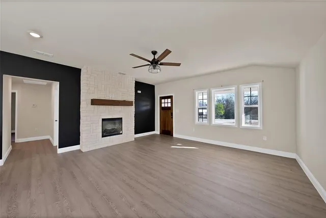 wooden floor fireplace and windows in an empty room