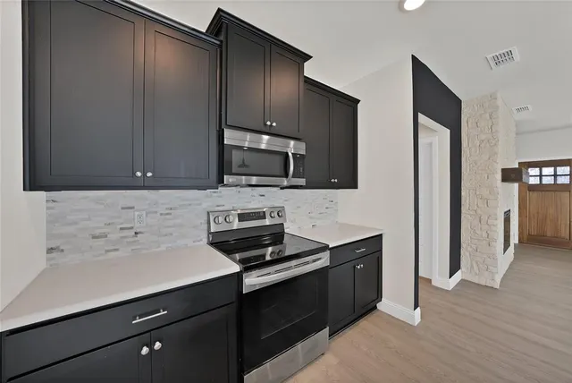 a kitchen with a sink appliances and cabinets