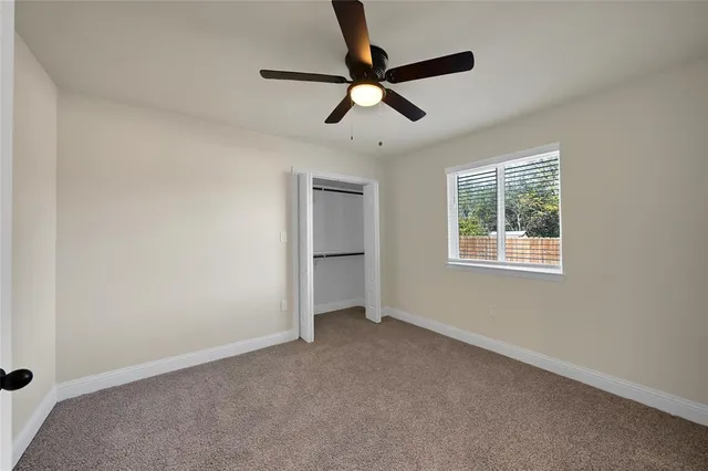 a view of room with ceiling fan and windows
