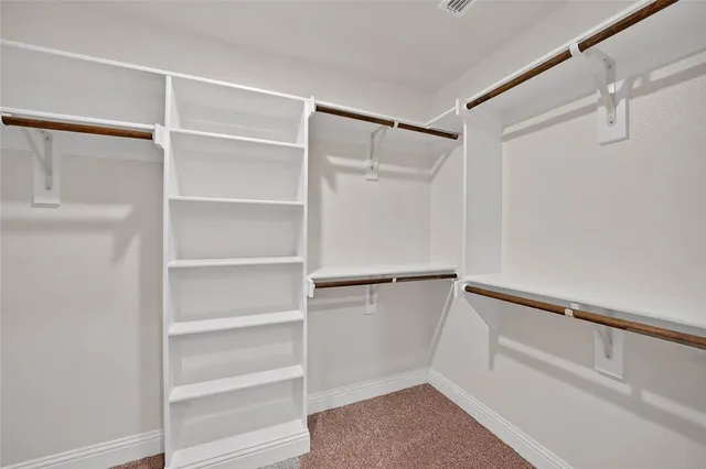 a view of walk in closet with empty racks