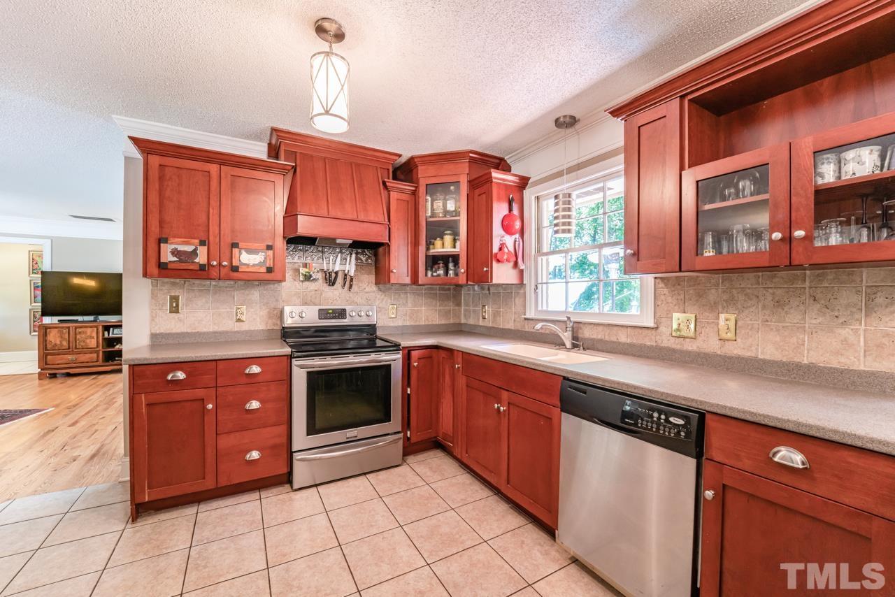 3318 Hampton Road Raleigh, NC 27607 - Photo 20 of 56 a kitchen with stainless steel appliances granite countertop a stove a sink and a microwave