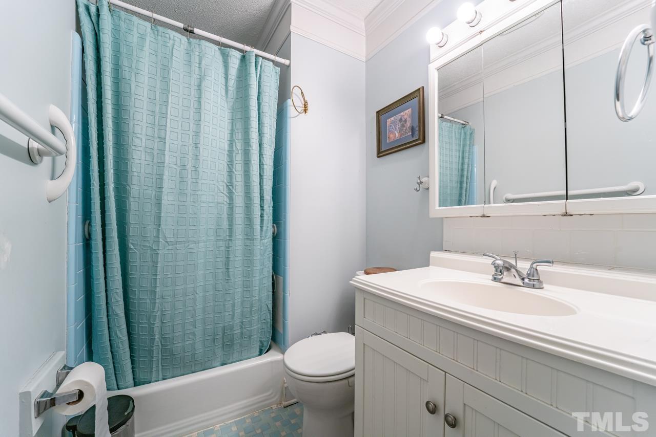 3318 Hampton Road Raleigh, NC 27607 - Photo 30 of 56 a bathroom with a sink a toilet a mirror and shower curtain
