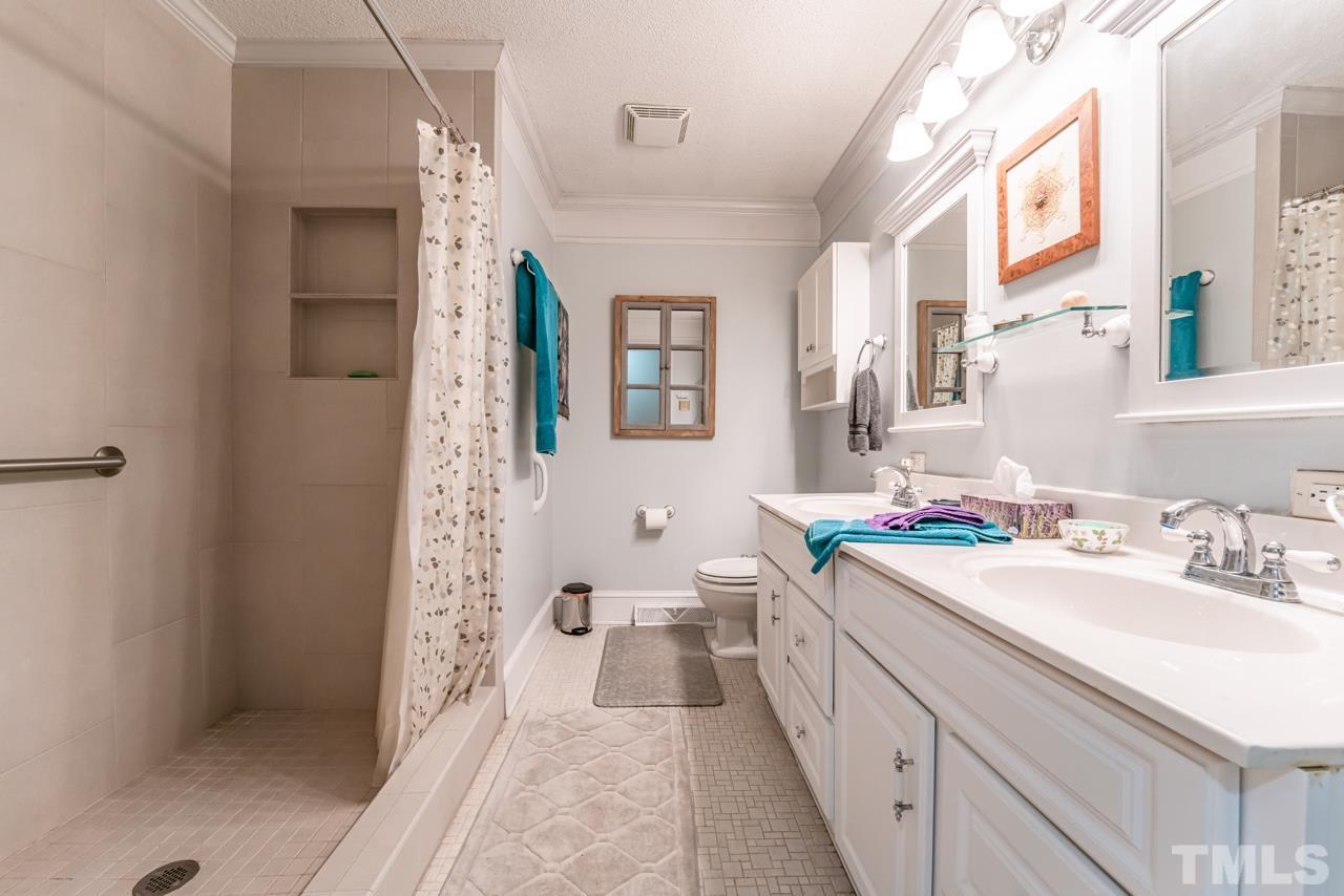 3318 Hampton Road Raleigh, NC 27607 - Photo 32 of 56 a bathroom with a sink a mirror and a toilet
