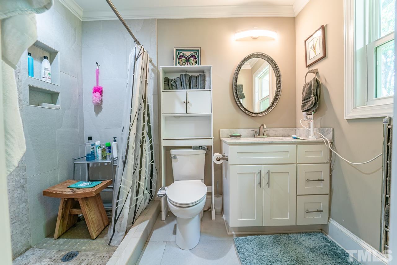 3318 Hampton Road Raleigh, NC 27607 - Photo 45 of 56 a bathroom with a toilet a sink and a mirror