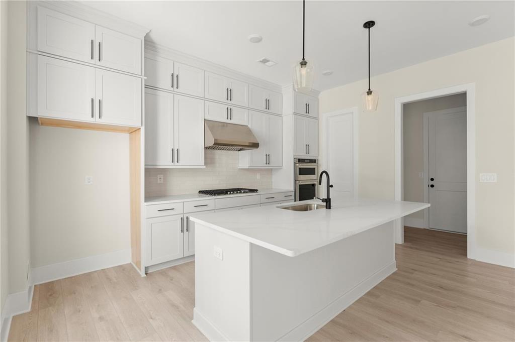 3552 Cedarvale Court Powder Springs, GA 30127 - Photo 14 of 46 a kitchen with stainless steel appliances a white stove top oven and white cabinets