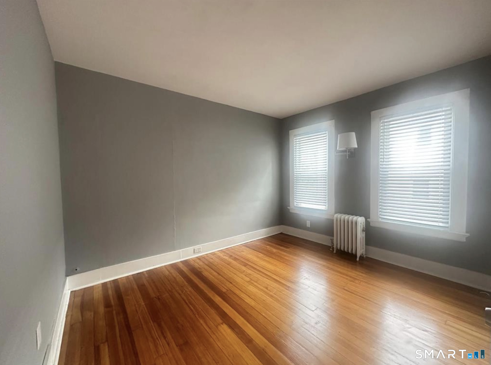 49 Dutton Street Wallingford, CT 06492 - Photo 8 of 10 an empty room with wooden floor and windows