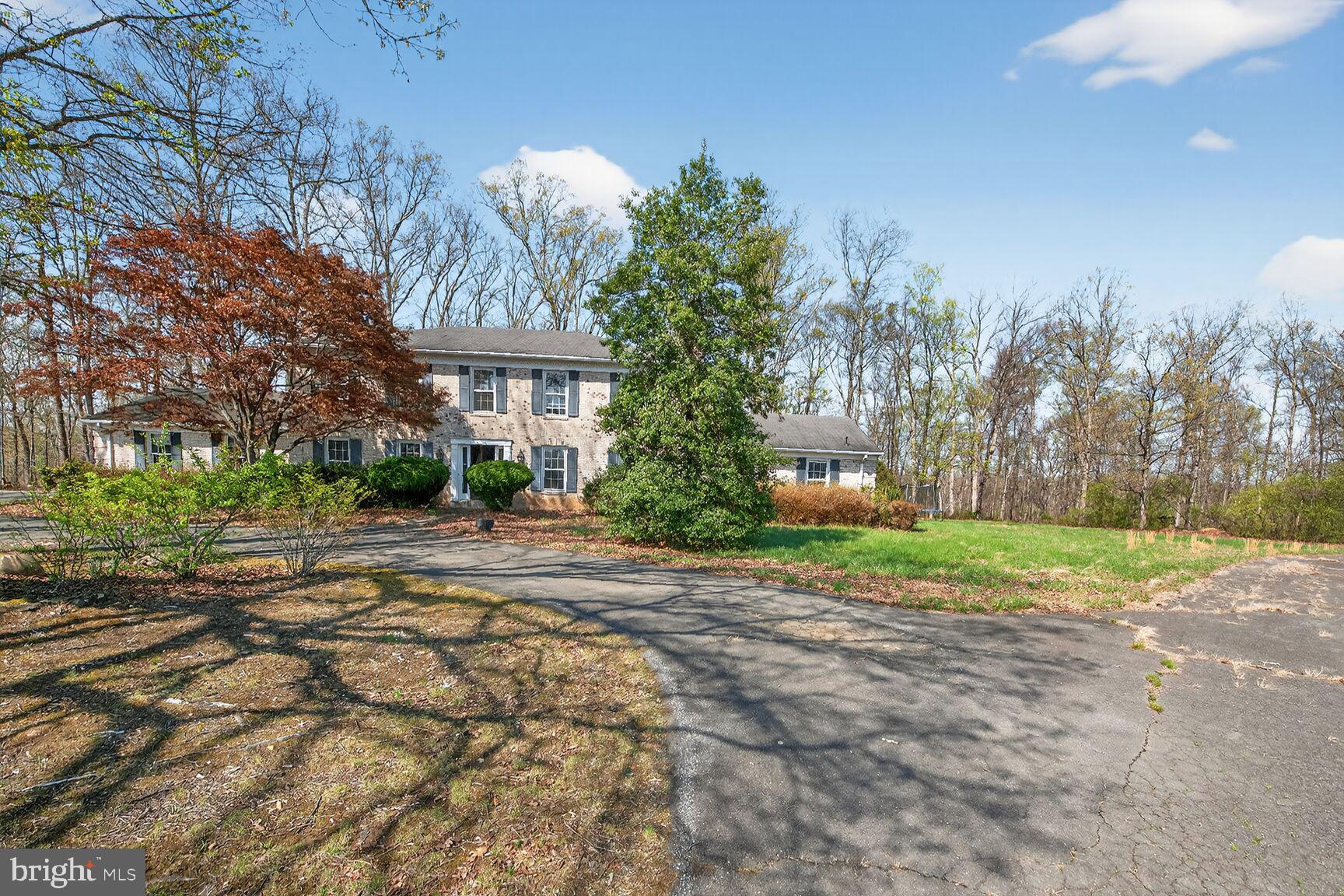 a front view of a house with a yard and trees