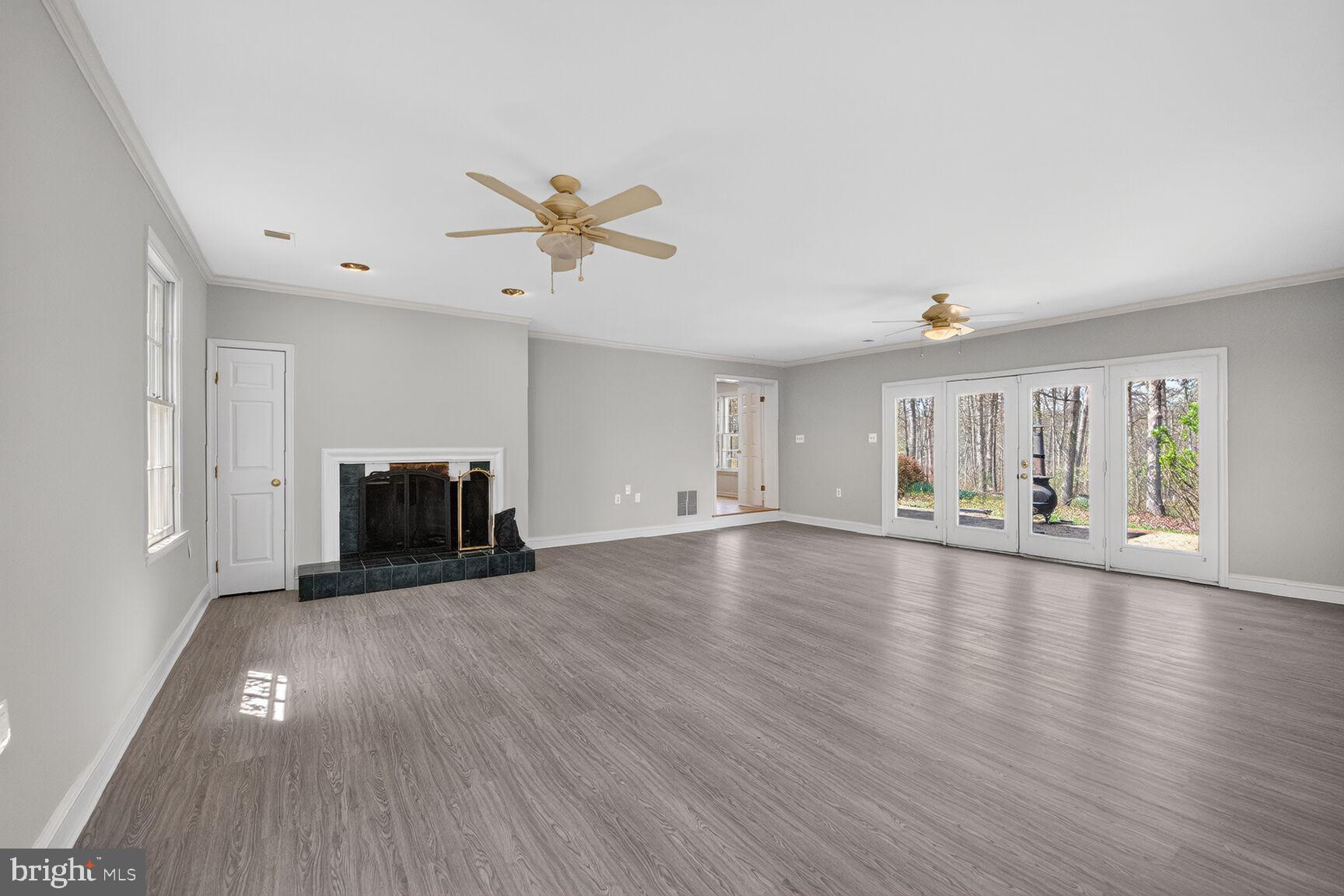 21733 Oatlands Road Aldie, VA 20105 - Photo 14 of 50 a view of empty room with wooden floor and fireplace