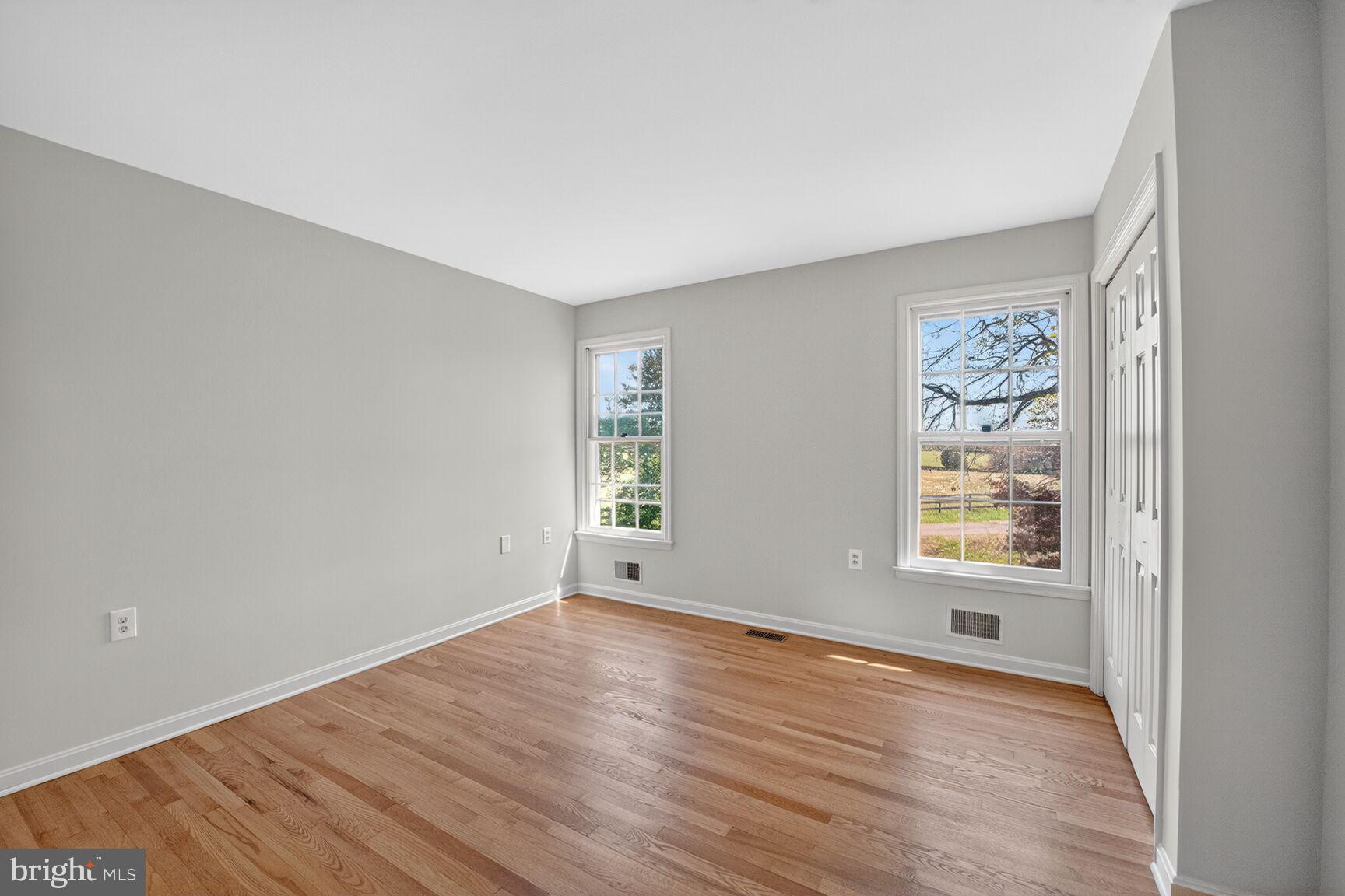 21733 Oatlands Road Aldie, VA 20105 - Photo 31 of 50 an empty room with wooden floor and windows