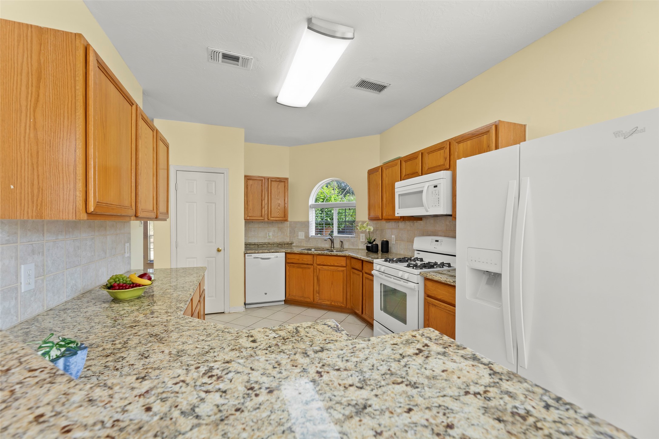 14715 Rancho Vista Drive Houston, TX 77083 - Photo 13 of 38 a kitchen with stainless steel appliances a stove a refrigerator a sink a oven with white cabinets and wooden floor