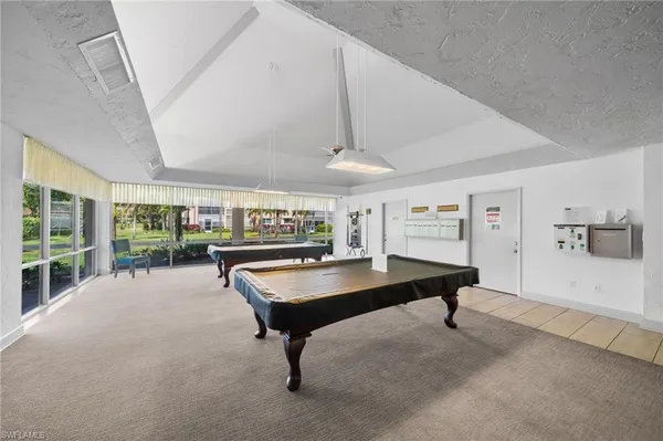 a living room with furniture pool table and a large window