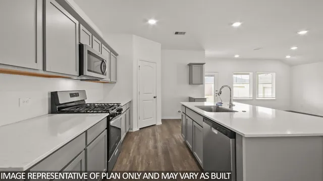 a kitchen with stainless steel appliances granite countertop a sink stove and cabinets
