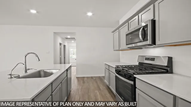 a kitchen with stainless steel appliances granite countertop a sink stove and microwave