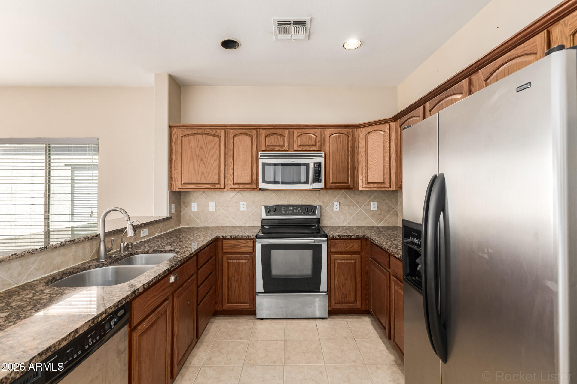 28314 North Crimm Road San Tan Valley, AZ 85143 - Photo 12 of 31 a kitchen with stainless steel appliances granite countertop a sink stove and refrigerator