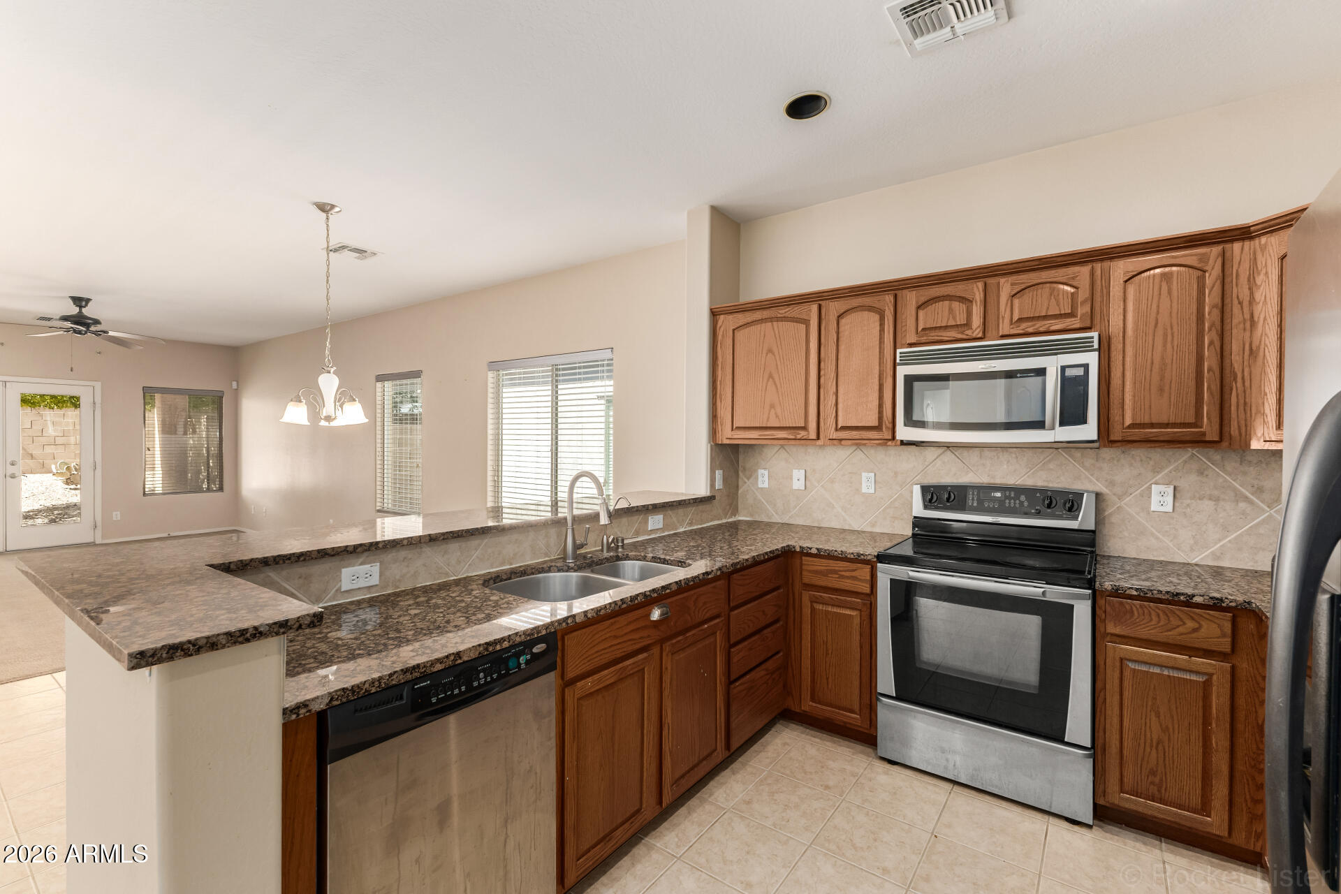 28314 North Crimm Road San Tan Valley, AZ 85143 - Photo 13 of 31 a kitchen with granite countertop stainless steel appliances and wooden cabinets