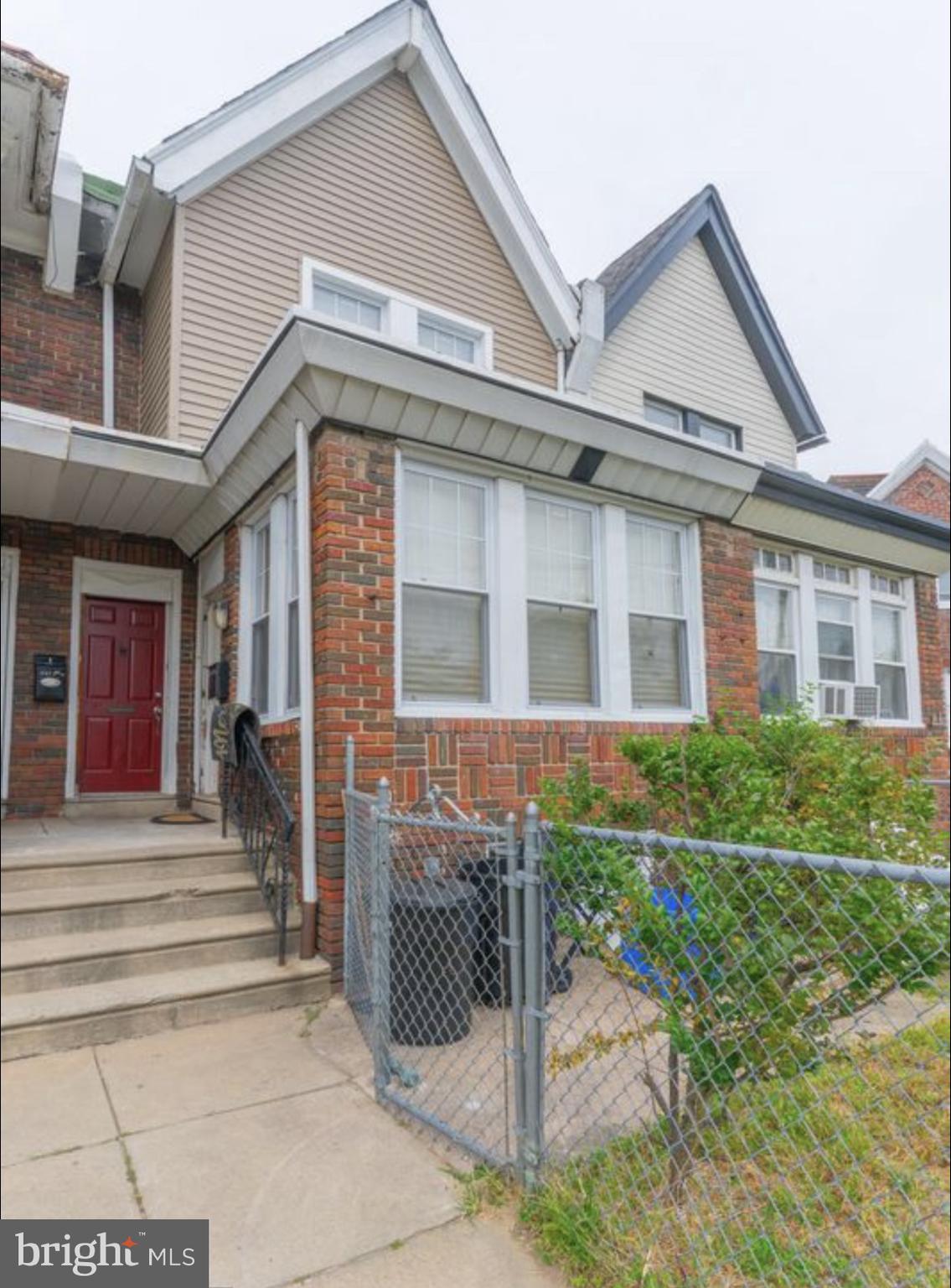 a front view of a house with a garden and plants