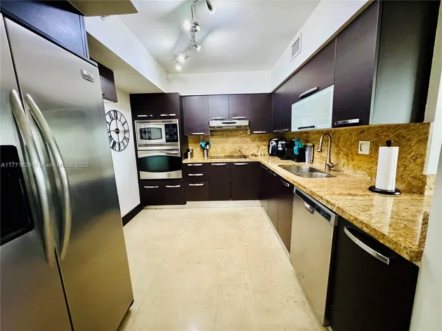 a kitchen with stainless steel appliances a sink stove and cabinets
