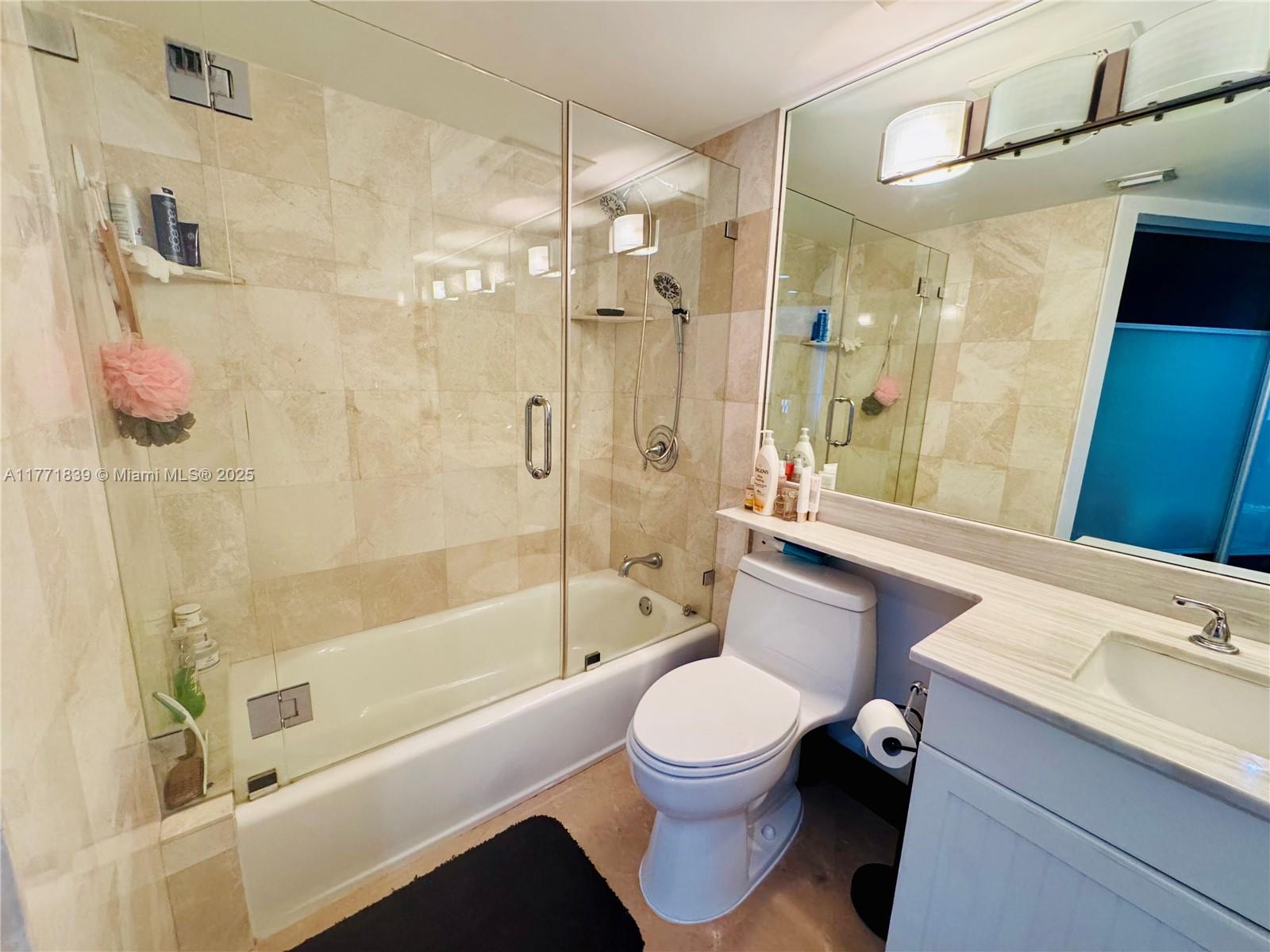 3600 Mystic Pointe Drive, Unit 1210 Aventura, FL 33180 - Photo 22 of 68 a bathroom with a bathtub shower sink mirror vanity and toilet