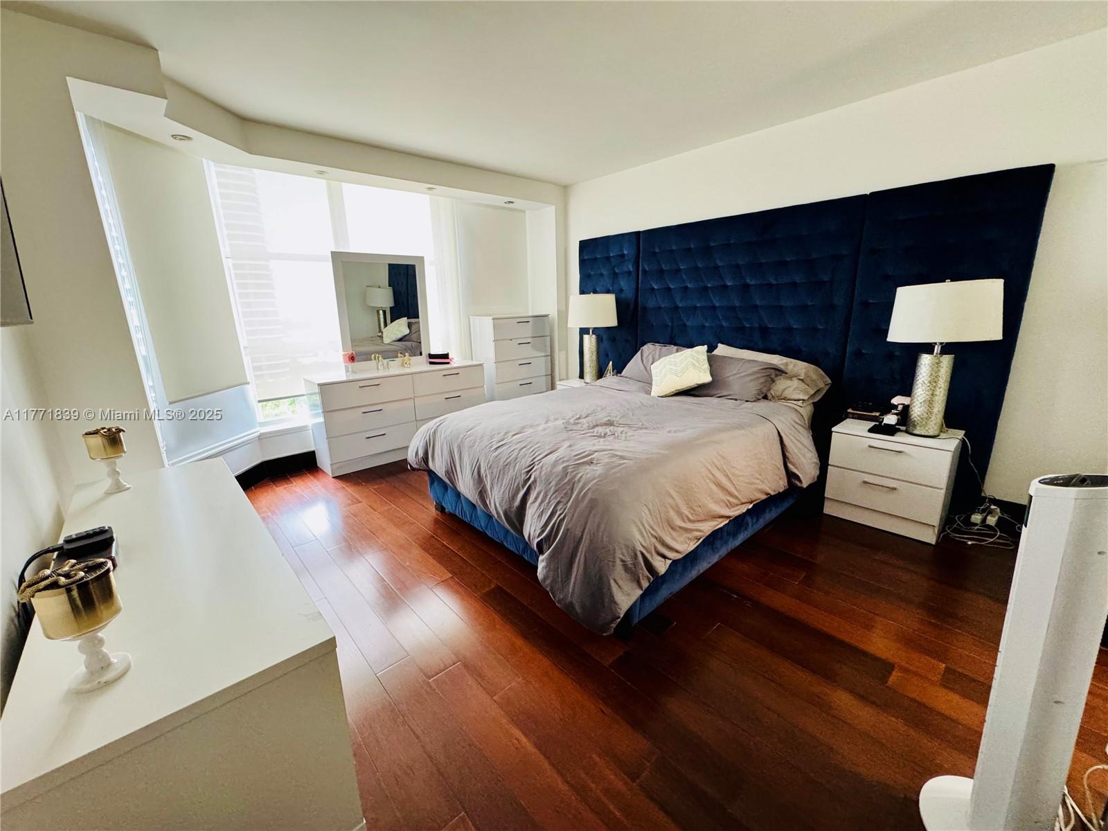 3600 Mystic Pointe Drive, Unit 1210 Aventura, FL 33180 - Photo 23 of 68 a bedroom with a bed and wooden floor