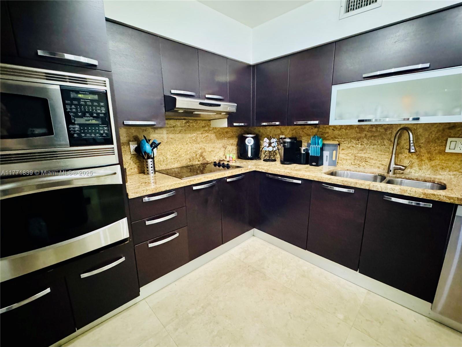 3600 Mystic Pointe Drive, Unit 1210 Aventura, FL 33180 - Photo 3 of 68 a kitchen with stainless steel appliances a sink stove and cabinets