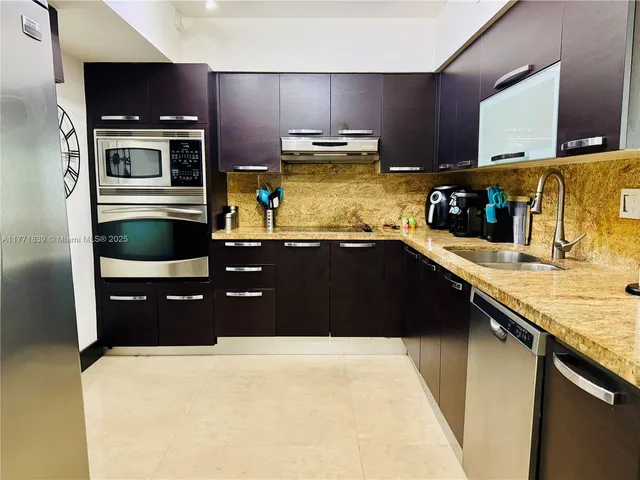 a kitchen with stainless steel appliances a refrigerator a sink a stove and cabinets