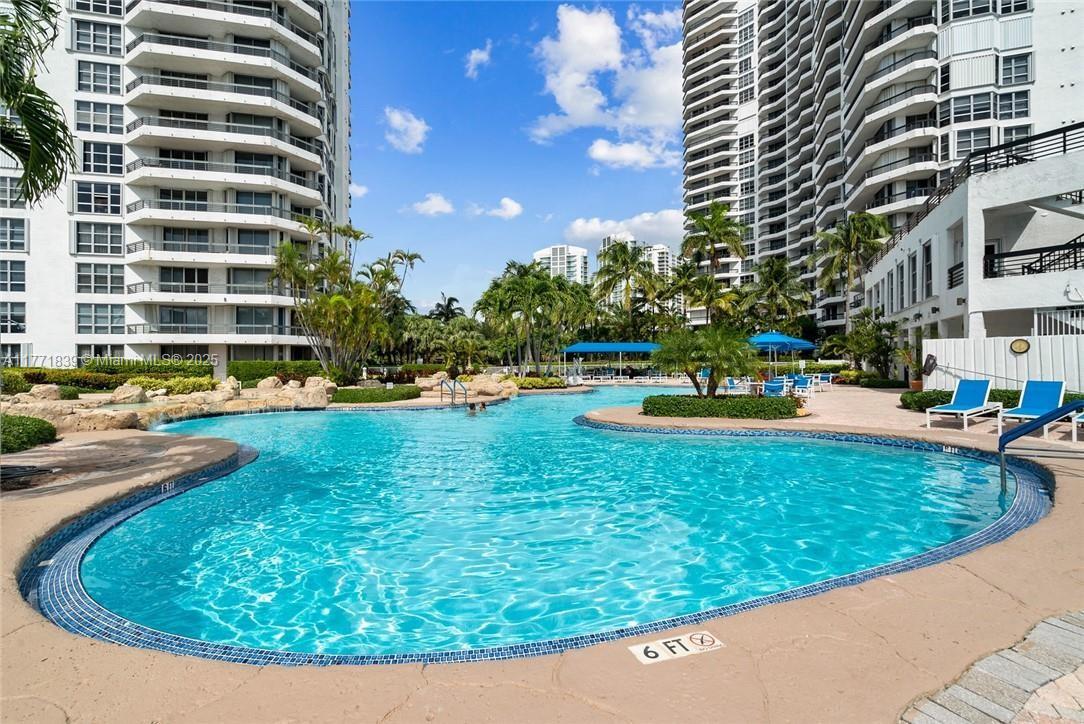 3600 Mystic Pointe Drive, Unit 1210 Aventura, FL 33180 - Photo 55 of 68 a view of a swimming pool with a yard and sitting space