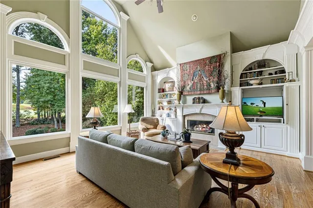 a kitchen with stainless steel appliances granite countertop a stove a sink dishwasher a microwave oven and a dining table with wooden floor