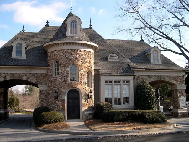 a view of a garden with lawn chairs under an umbrella