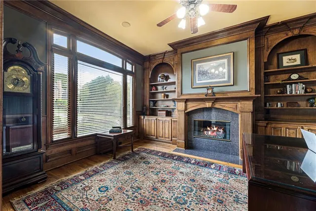 a living room with furniture a fireplace and a floor to ceiling window