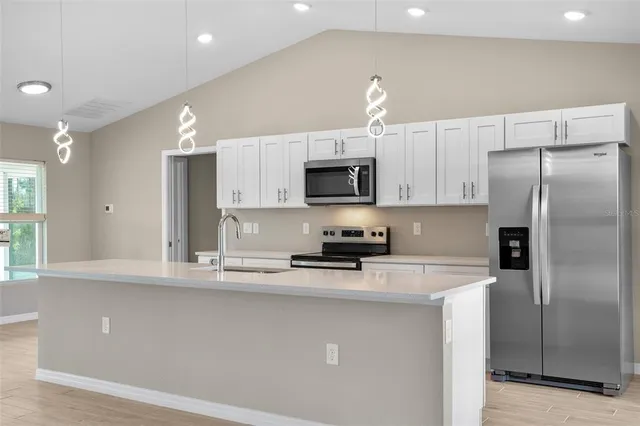 a kitchen with stainless steel appliances a refrigerator sink and microwave