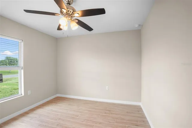 an empty room with a window and a fan