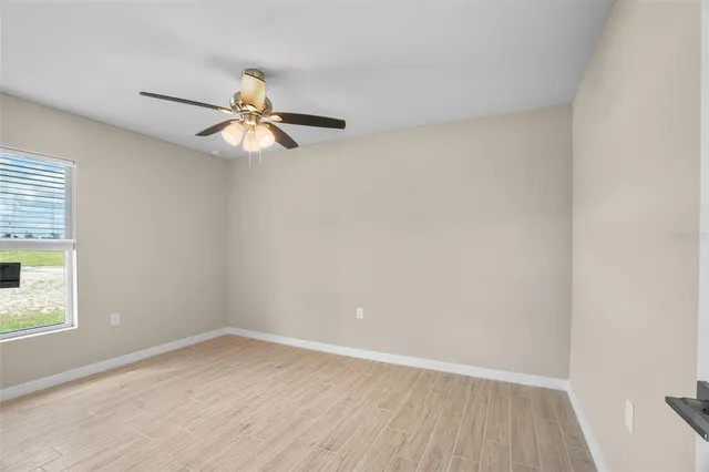 an empty room with a window and a fan