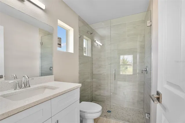 a bathroom with a sink toilet a mirror and shower