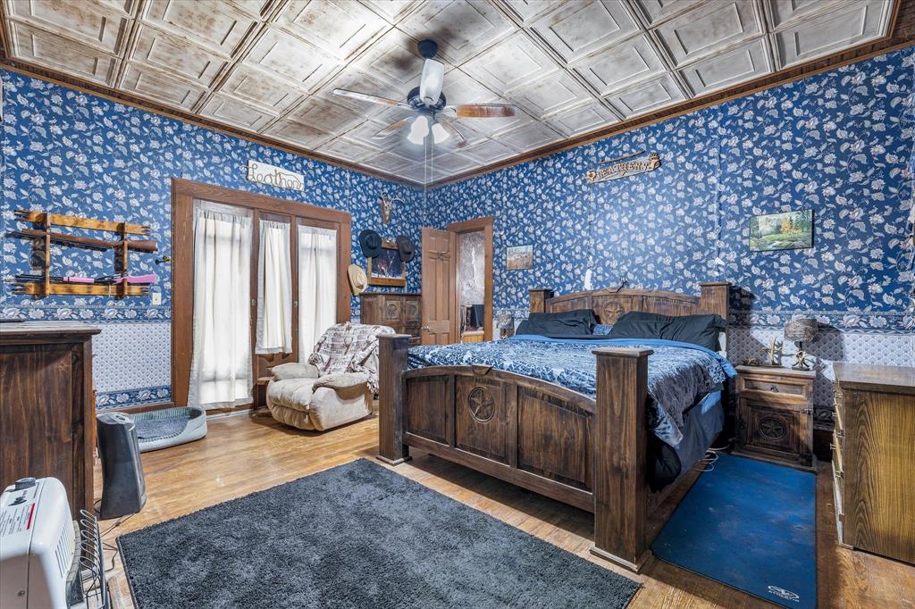421 Huey Avenue Mount Calm, TX 76673 - Photo 13 of 39 a bedroom with a bed and wooden floor