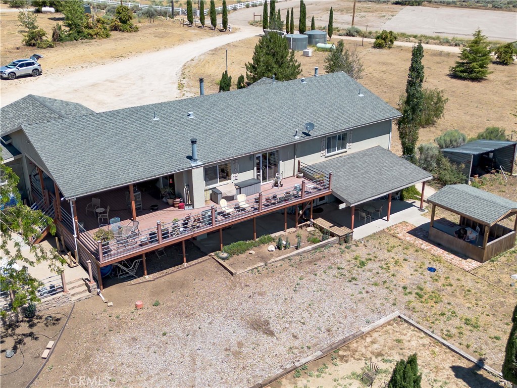 10960 Steinhoff Road Frazier Park, CA 93225 - Photo 7 of 46 A detailed aerial perspective highlighting the rear of the residence, showcasing the expansive multi-level wooden deck perfect for entertaining, a detached covered patio gazebo, and a broad view of the driveway and surrounding property.