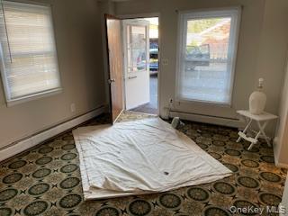 146-148 Ridge Street Pearl River, NY 10965 - Photo 11 of 19 LL The room features patterned carpeting, two windows with blinds, and painted walls